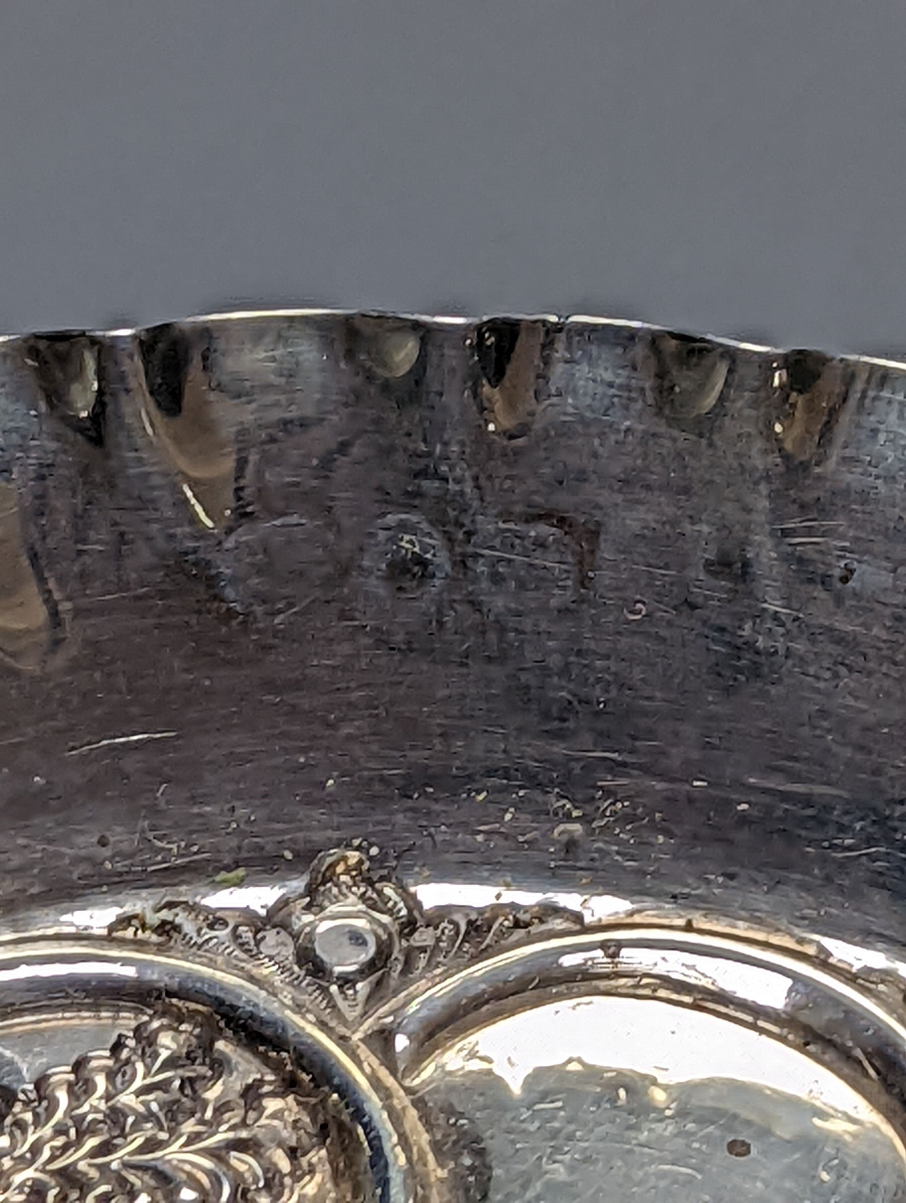 A pair of late Victorian repousse silver tri-handled shallow nut dishes, Vale Brothers & Serman, Birmingham, 1898, 13.7cm, 135 grams.